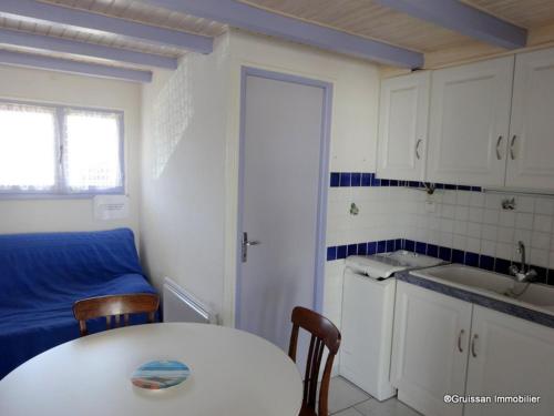 une petite cuisine avec une table blanche et un évier dans l'établissement Chalet cosy à 400m de la plage avec terrasse et parking - 2 chambres, 4 pers. - FR-1-784-17, à Gruissan