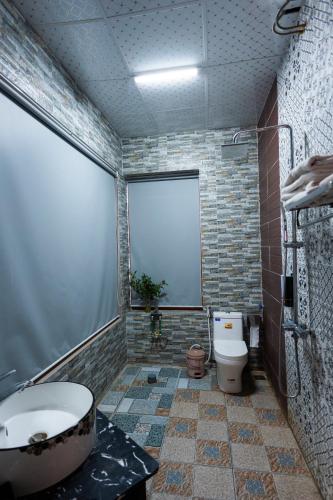 a bathroom with a tub and a toilet and a sink at Rosa Garden in Ninh Binh