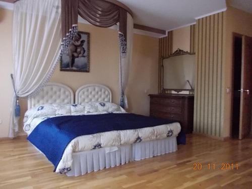 a bedroom with a bed with a blue blanket and a dresser at Rayske Yabloko in Lviv