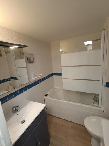 une salle de bain avec une baignoire, un lavabo et des toilettes dans l'établissement T3 Duplex, centre port, clim, garage, piscine, au Cap d'Agde
