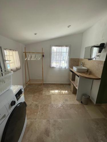 une petite cuisine avec un évier et une cuisinière dans l'établissement La l Isloise, à LʼIsle-sur-la-Sorgue