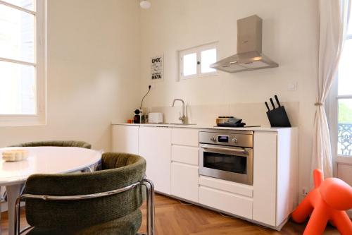 une cuisine avec une cuisinière et une table avec des chaises dans l'établissement CASA DOM ARMANDO - Climatisation & Parking, à Montpellier