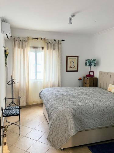 a bedroom with a large bed and a window at Erike Guest House in Carvoeiro
