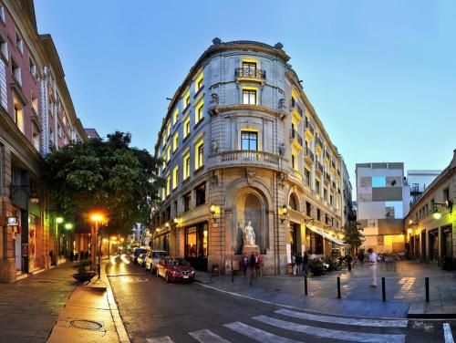 a large building on a city street at night at Hotel 1898 in Barcelona