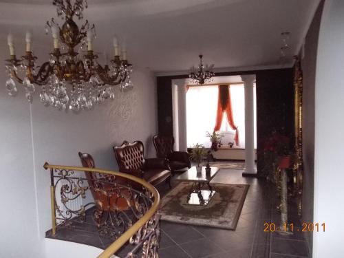 a living room with a chandelier and a table and chairs at Rayske Yabloko in Lviv