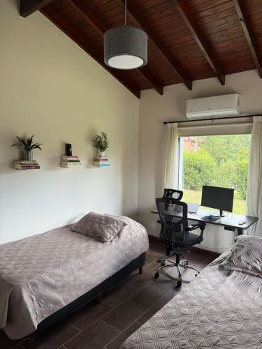 una camera da letto con un letto e una scrivania con un computer di Nomad Base en Country Chumamaya a Merlo