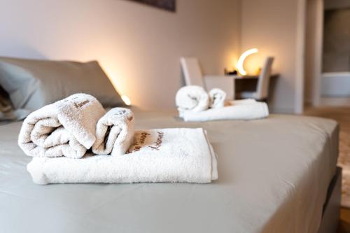 two towels are sitting on top of a bed at San Carlo Premium - Torino Centro in Turin
