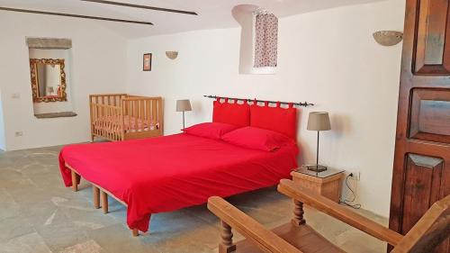 a red bed with red pillows in a bedroom at Lago Maggiore - Verbania - Appartamento Piano Terra - La Casaccia in Verbania