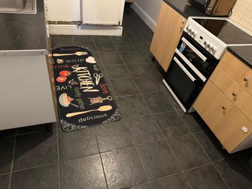 a kitchen with a sign on the floor next to a stove at A Place to stay in Kettering in Kettering