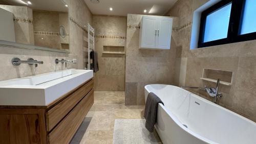 La salle de bains est pourvue d'une grande baignoire et d'un lavabo. dans l'établissement Contemporary Villa Opio, à Opio
