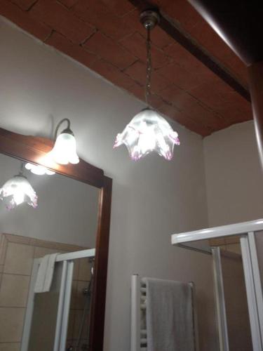 a bathroom with two lights and a mirror at B&B Il Casale di Nanni in Lucca