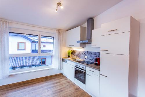 a kitchen with white cabinets and a window at City Dream 1 by Alpenidyll Apartments in Schladming