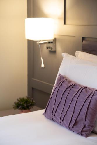 a bed with a purple pillow and a lamp at Kilkenny House Boutique Hotel in Kilkenny