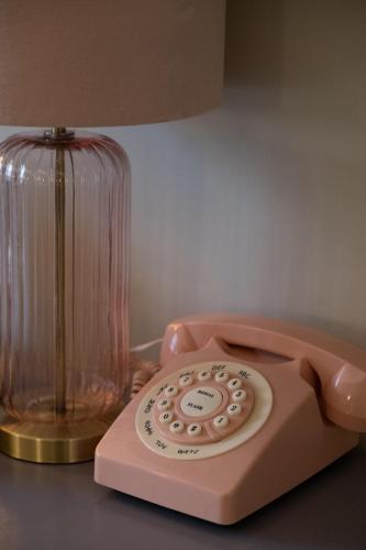 a pink phone sitting on a table next to a lamp at Kilkenny House Boutique Hotel in Kilkenny
