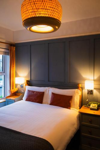 a bedroom with a large white bed and a lamp at Kilkenny House Boutique Hotel in Kilkenny