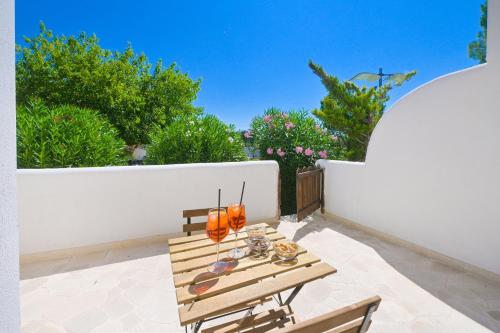 a table and chairs on a patio with a white wall at Relais Porta del Sud in Ostuni