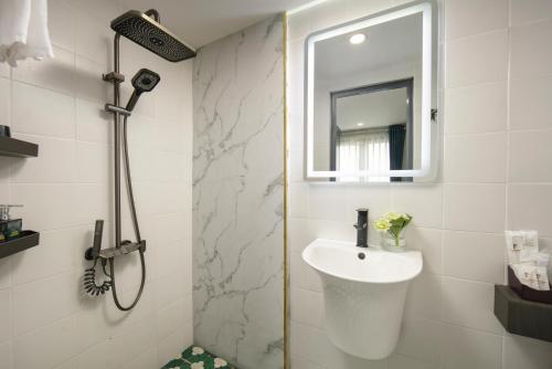 a white bathroom with a sink and a mirror at La Palm Boutique Hotel in Hanoi