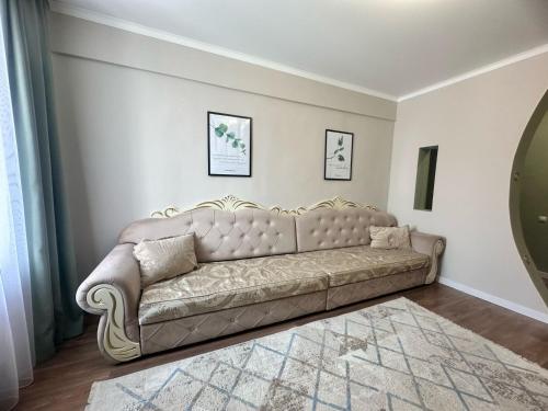 a couch in a living room with a mirror at LUX HOME на Дворце Металлургов in Ustʼ-Kamenogorsk