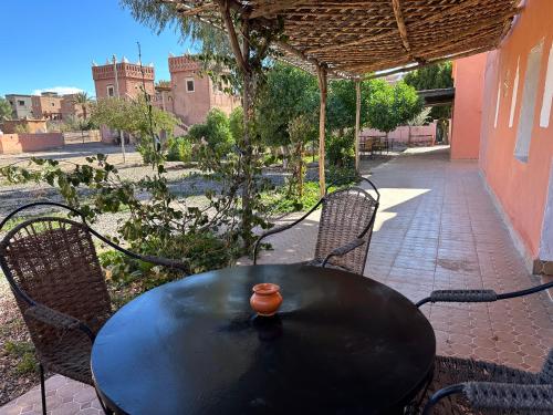 a black table with chairs and a bowl on top at La Kasbah du Jardin in Aït Ben Haddou