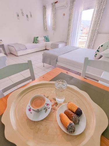 a table with two plates of food and a cup of coffee at Menta Studios in Skala Potamias