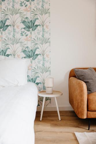 a bedroom with a bed and a chair at Le Refuge de la Rive in Guichen