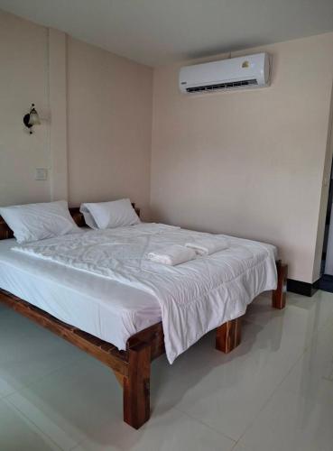 une chambre avec un grand lit avec deux serviettes dessus dans l'établissement Mirinda Beach Resort, à Ban Bo Daeng