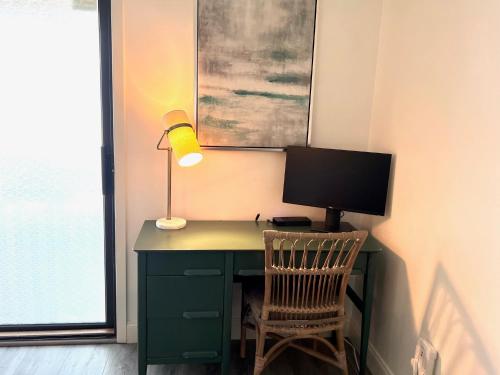 a desk with a computer and a lamp and a chair at 1621 courtside in Seabrook Island