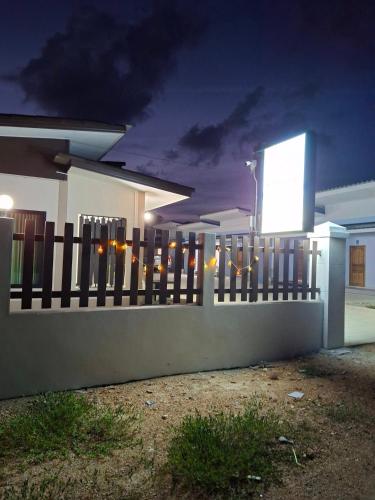 a fence in front of a house at night at Mirinda Beach Resort in Ban Bo Daeng