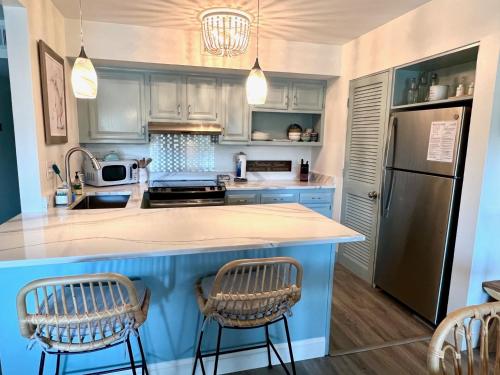a kitchen with a blue island with two bar stools at 1621 courtside in Seabrook Island
