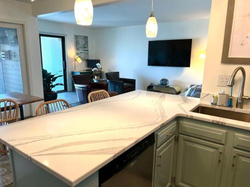 a kitchen with a sink and a living room at 1621 courtside in Seabrook Island