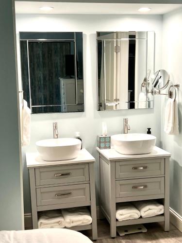 a bathroom with two sinks and two mirrors at 1621 courtside in Seabrook Island