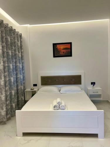 a white bed in a white bedroom with at Villa Festim Ksamil in Ksamil