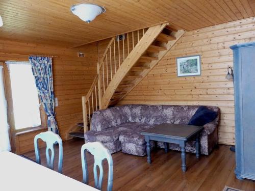 哈瑟尔费尔德Ferienhaus Nr 23, Typ A, Ferienanlage Blauvogel, Hasselfelde, Harz的客厅里有一张沙发和一张桌子。