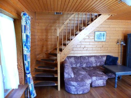 哈瑟尔费尔德Ferienhaus Nr 23, Typ A, Ferienanlage Blauvogel, Hasselfelde, Harz的带沙发和楼梯的客厅