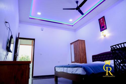 a bedroom with a ceiling fan and a bed at Crown residency in Changanācheri
