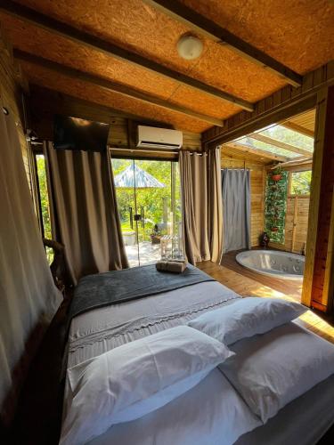 a bedroom with a bed and a tub in a room at Cabana Canadense, Vem Relaxar e Desconectar in Imaruí