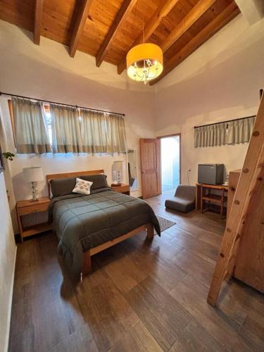 a bedroom with a bed and a living room at Hotel bugambilias in Valle de Bravo