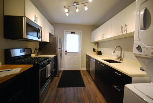 a kitchen with white cabinets and a stove top oven at Brookwood Courtyard by BCA Furnished Apartments BCC1B 06 F in Atlanta