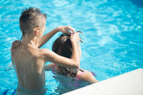 a young boy and girl in a swimming pool at Apartments Dania in Lopar