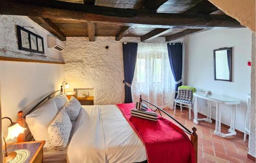 a bedroom with a bed and a table and a chair at 2 Bedroom Cozy Home In Lovran in Lovran