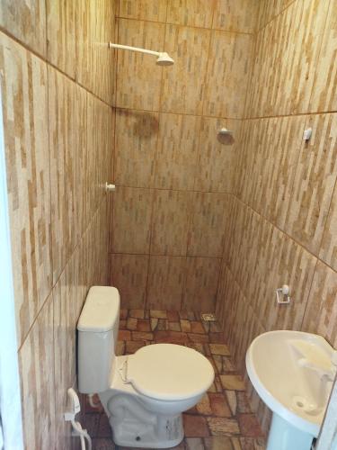 a bathroom with a toilet and a sink at Algodoal Pousada 3 Irmãos in Maracanã