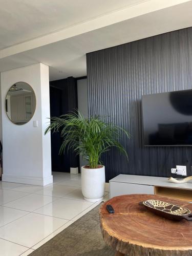 Una sala de estar con una mesa y un televisor. en Desert Pearl, en Windhoek