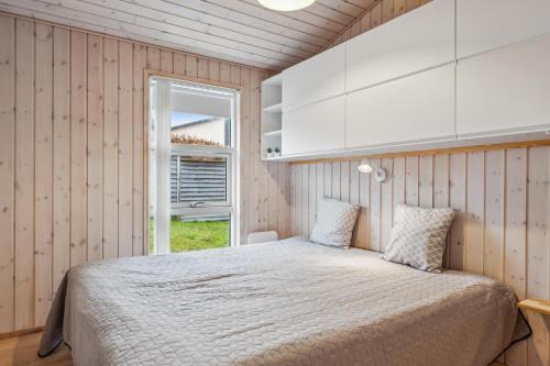 une chambre avec un lit et une fenêtre dans l'établissement Beautiful And Well-Designed Holiday Home With Sea View, Spacious Terraces And Spa Just 200 Metres From The Child-Friendly Femmøller Beach And Close, à Ebeltoft