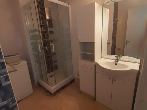 une salle de bain blanche avec un lavabo et une douche dans l'établissement Charmant F2 avec terrasse près de l'Étang de Thau, équipé pour 4 pers. et proche établissement thermal - FR-1-571-41, à Balaruc-les-Bains