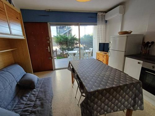 une petite cuisine avec une table et un réfrigérateur dans l'établissement Charmant F2 avec terrasse près de l'Étang de Thau, équipé pour 4 pers. et proche établissement thermal - FR-1-571-41, à Balaruc-les-Bains