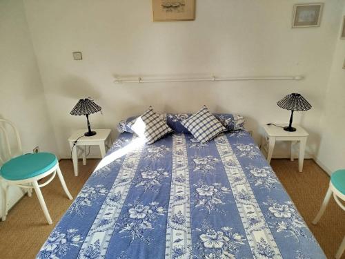 un lit bleu et blanc avec deux tables et deux lampes dans l'établissement Charmant T2 à La Favière avec piscine et parking privé, proche plages et commerces - FR-1-610-13, à Bormes-les-Mimosas