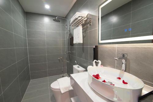 a bathroom with a sink and a toilet and a mirror at Riverside Quảng Yên Hotel in Quảng Yên