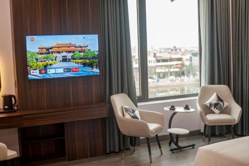 a hotel room with a flat screen tv on a wall at Riverside Quảng Yên Hotel in Quảng Yên