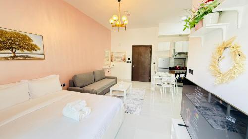 a bedroom with a bed and a living room at Lawnz Luxury furnished studio with Balcony Swimming Pool Gym Kids play ground in Dubai