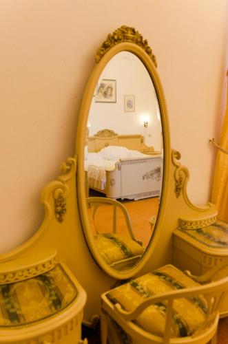 a mirror on a wall with a bed in a room at Ēdoles Pils in Ēdole